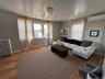 Living area featuring wood-finish flooring, decorative wall molding, and multiple windows