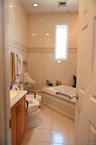 Full bathroom with vanity, a bidet, tile walls, and light tile patterned floors