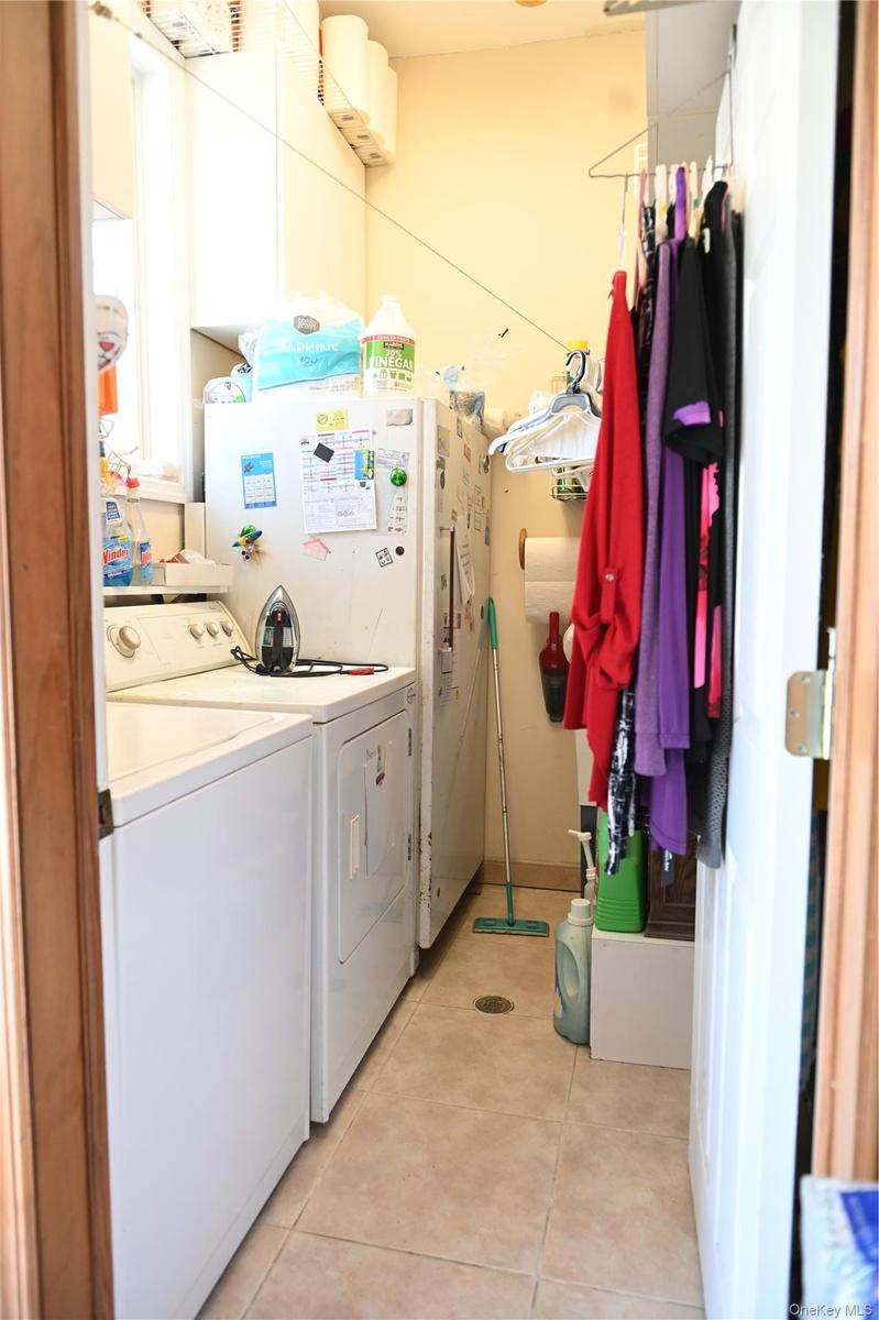 Washroom featuring light tile patterned floors and separate washer and dryer