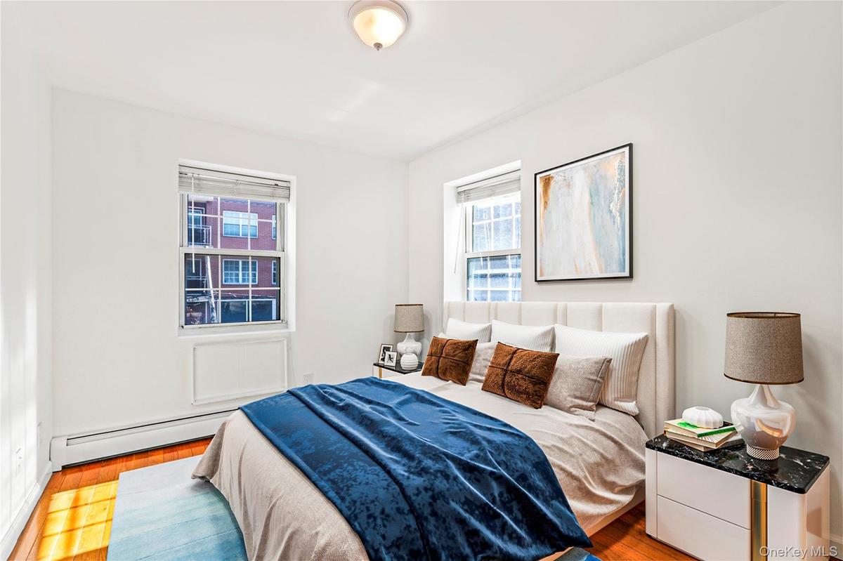 Virtual Staged Bedroom with a baseboard heating unit and wood finished floors