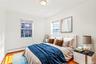 Virtual Staged Bedroom with a baseboard heating unit and wood finished floors