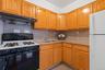 Kitchen featuring sink, gas stove, tasteful backsplash, white fridge, and range hood
