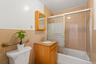 Full bathroom featuring vanity, tile walls, shower / bath combination with glass door, and toilet