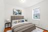 Virtual Staged Bedroom featuring baseboard heating, wood finished floors, and baseboards