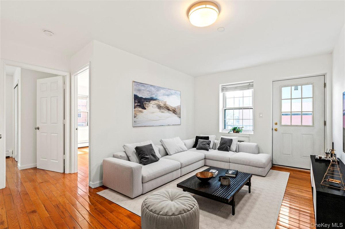 Virtual Staged Living area with light wood-type flooring and baseboards