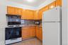 Kitchen featuring sink, white refrigerator, extractor fan, decorative backsplash, and range with gas cooktop