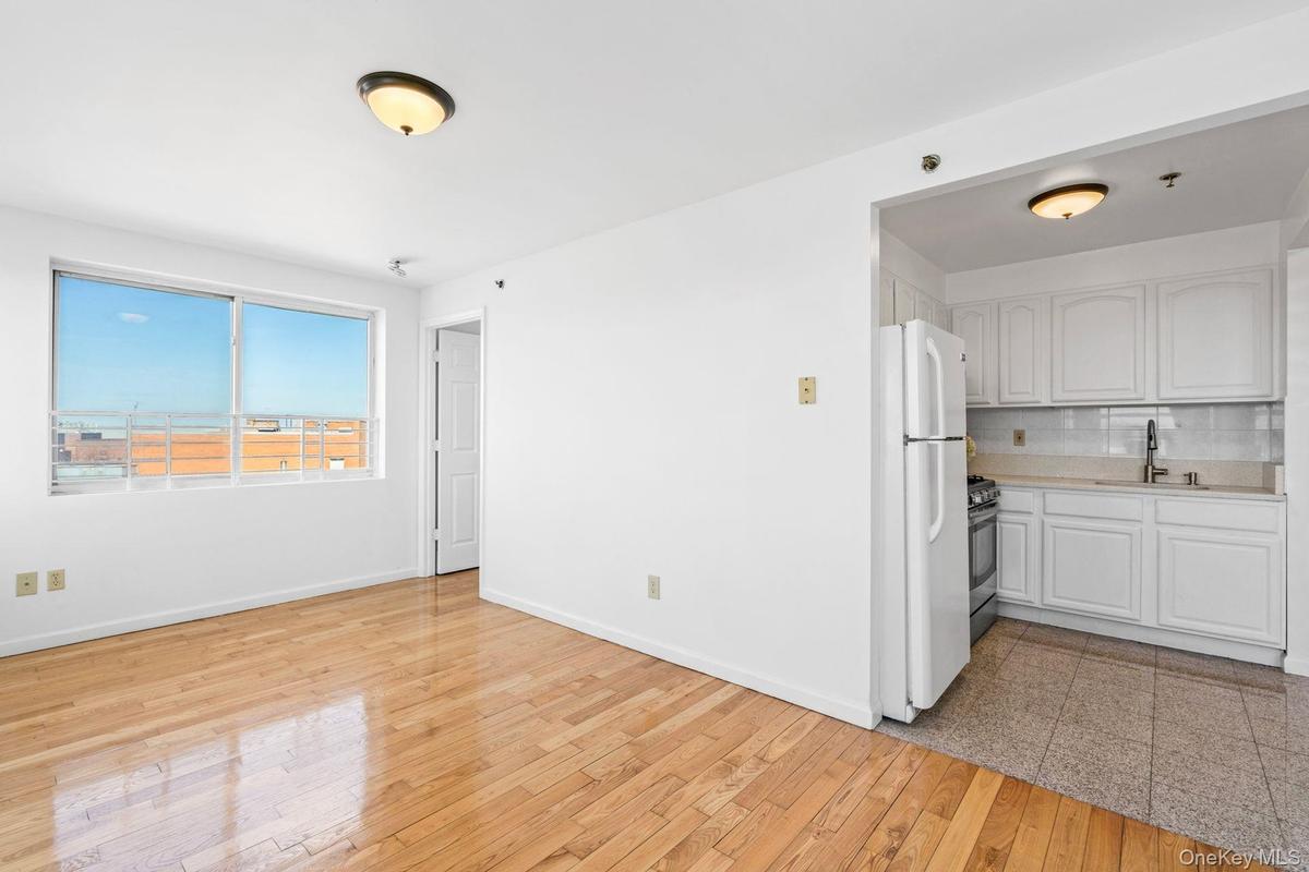 Kitchen with white cabinetry, sink, decorative backsplash, white refrigerator, and gas stove