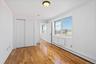 Unfurnished bedroom with a baseboard radiator, a closet, and light wood-type flooring