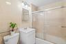 Full bathroom featuring vanity, toilet, combined bath / shower with glass door, and tile walls