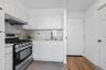 Kitchen with white cabinetry, sink, tasteful backsplash, and gas stove
