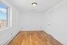 Empty room featuring a baseboard heating unit and light wood-type flooring