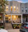 Inviting facade featuring a columned front porch, bay windows, and a dark entry door