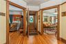 Hardwood flooring throughout the entry area, featuring ornate wood door frames and crown molding