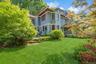 Lush green lawn with mature landscaping and flowering shrubs