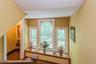 Ornate window alcove featuring three windows with decorative muntins, a central arched window, and a built-in wood window seat