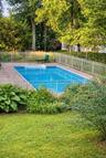 In-ground swimming pool with stone paver surround