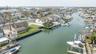 Waterfront property featuring a private boat dock, expansive backyard, sunroom with multiple skylights, and a two-story residence with a prominent chi
