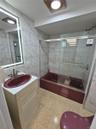 Full bath featuring tile walls, combined bath / shower with glass door, and vanity