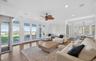 Bright living space with wood-finish flooring and extensive white French doors