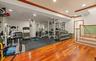 Dedicated fitness area featuring rubber flooring, recessed lighting, and a wood-finish flooring portion