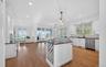 Open-concept kitchen and living area featuring wood-finish flooring, recessed lighting, and expansive glass doors