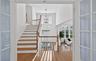Grand entry foyer with a sweeping staircase featuring wood-finish treads and white risers