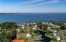 Expansive waterfront community featuring a marina, winding roads, mature landscaping, and multiple residences