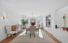 Formal dining area featuring hardwood flooring, crown molding, a bay window, and a built-in wall niche
