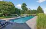 Elongated swimming pool with bluestone coping and surrounding patio