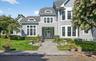 Traditional-style residence featuring light gray siding, white trim, and a prominent front entry with a transom window