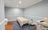 Room featuring hexagonal terracotta-style flooring, light-toned walls with chair rail molding, and a drop ceiling with recessed lighting