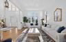 Spacious living area featuring high ceilings, hardwood flooring, large windows, a prominent entry door with sidelights, and a decorative chandelier