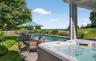 Outdoor entertaining space featuring a rectangular swimming pool, integrated hot tub, and stone patio
