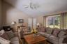 Living area featuring vaulted ceilings, wood-finish flooring, and a ceiling fan