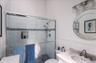 Shower with glass enclosure, white subway tile surround with mosaic accent, and recessed niche