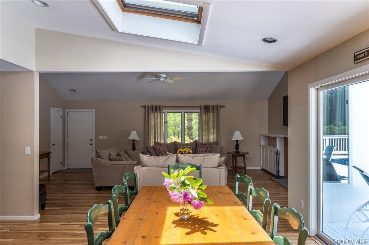 Open-concept interior featuring wood-finish flooring, a skylight, and recessed lighting