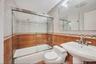 Bathroom featuring tile walls and shower / bath combination with glass door