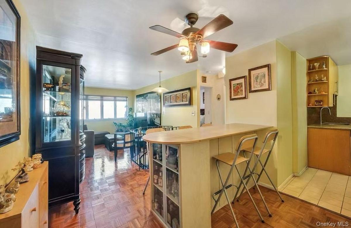 Kitchen featuring open shelves, a breakfast bar area, a peninsula, hanging light fixtures, and light countertops