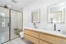 Bathroom featuring a shower stall and double vanity