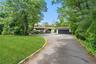 View of front of property featuring asphalt driveway, a front lawn, and a garage