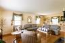 Living area with hardwood flooring, multiple windows, built-in shelving, and light-toned walls