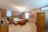 Carpeted room with sloped ceilings and a ceiling fan light fixture