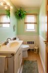 Bathroom featuring a vanity with an integrated sink, wood-finish flooring, and wainscoting