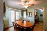 Dining area featuring wood-finish flooring, a ceiling fan with integrated lighting, and direct patio access through sliding glass doors