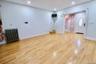 Spacious room featuring wood-finish flooring, recessed lighting, and a front entry door with an oval-shaped glass insert