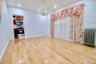 Spacious room featuring wood-finish flooring, a crystal chandelier, and recessed lighting