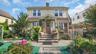 View of front of property featuring a chimney and stucco siding