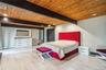 Bedroom with wooden ceiling with exposed beams, wood finished floors, and a baseboard heating unit