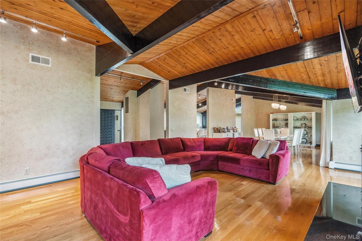 Living room featuring track lighting, wood finished floors, wooden ceiling, and baseboard heating