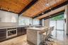 Kitchen featuring rail lighting, stainless steel appliances, a sink, and wooden ceiling